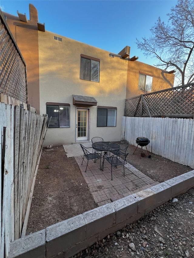 1666 Calle De Oriente Norte, Santa Fe, NM 87507 - back of house with a fenced backyard, stucco siding, and a patio