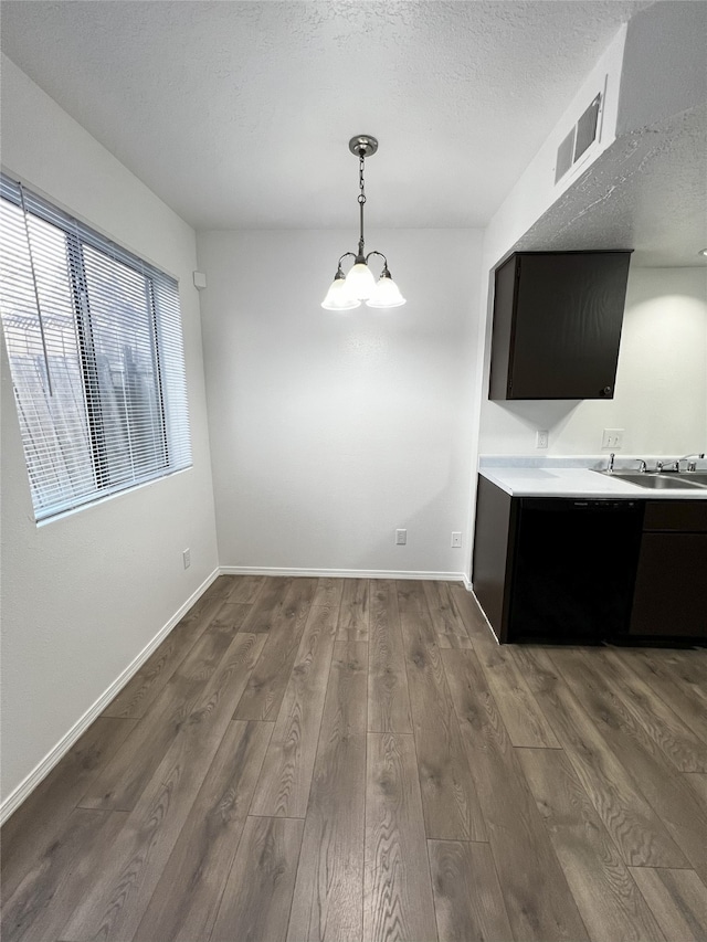 1666 Calle De Oriente Norte, Santa Fe, NM 87507 - unfurnished dining area featuring dark wood-style flooring, visible vents, baseboards, a sink, and a notable chandelier