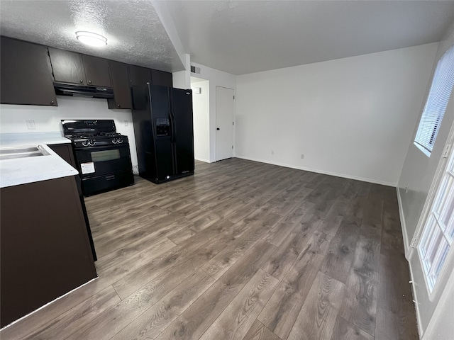 1666 Calle De Oriente Norte, Santa Fe, NM 87507 - kitchen featuring light countertops, visible vents, wood finished floors, under cabinet range hood, and black appliances