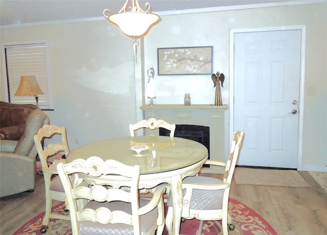 dining room with baseboards, wood finished floors, and crown molding