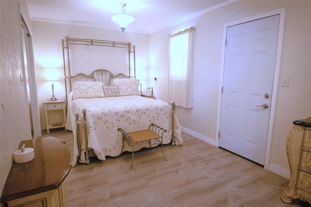 bedroom with light wood finished floors, baseboards, and crown molding