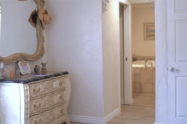 corridor with baseboards and light wood-type flooring