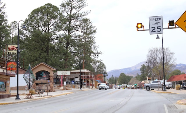 view of street featuring curbs, a mountain view, and sidewalks