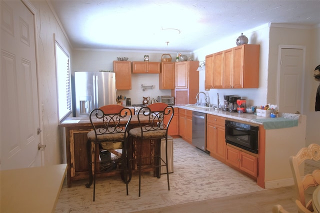 kitchen with crown molding, light countertops, a sink, appliances with stainless steel finishes, and a toaster