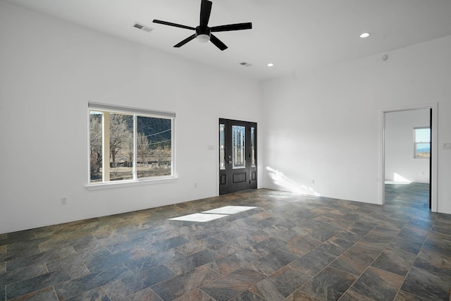 3 Cerro Cir, Lamy, NM 87540 - unfurnished room featuring visible vents, stone finish floor, a towering ceiling, ceiling fan, and recessed lighting