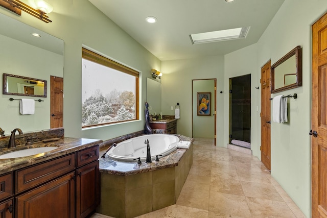 bathroom featuring a sink, a jetted tub, a shower stall, and two vanities