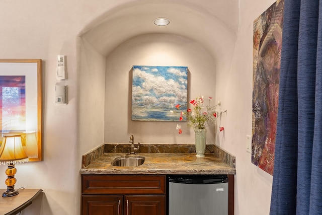 bar featuring refrigerator, a sink, and indoor wet bar