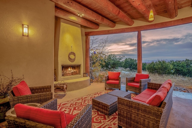 patio terrace at dusk with an outdoor living space with a fireplace