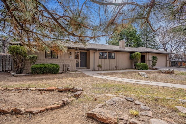 126 Andanada, Los Alamos, NM 87544 - single story home with a chimney, concrete driveway, board and batten siding, fence, and a garage