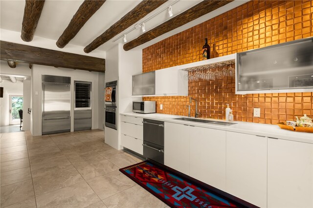 6 Overlook Rd, Santa Fe, NM 87505 - kitchen featuring beam ceiling, backsplash, a sink, stainless steel appliances, and white cabinets