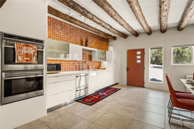 6 Overlook Rd, Santa Fe, NM 87505 - kitchen with light countertops, tasteful backsplash, appliances with stainless steel finishes, beamed ceiling, and white cabinets
