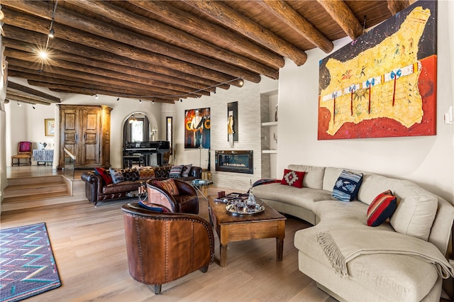 6 Overlook Rd, Santa Fe, NM 87505 - living room featuring light wood-type flooring, wooden ceiling, arched walkways, beam ceiling, and a glass covered fireplace