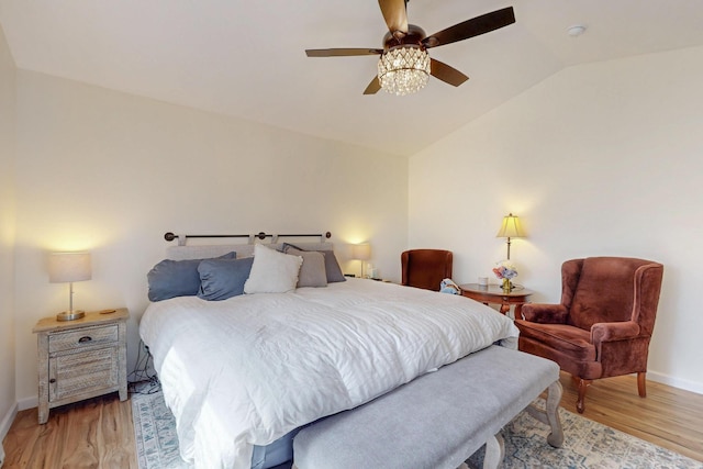 bedroom with a ceiling fan, baseboards, vaulted ceiling, and light wood-type flooring