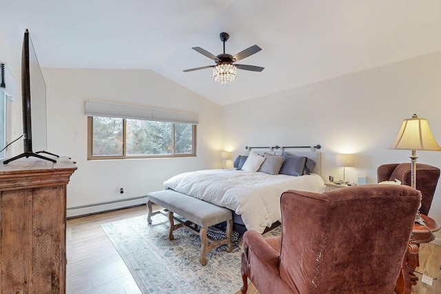 bedroom with lofted ceiling, wood finished floors, a baseboard heating unit, and a ceiling fan