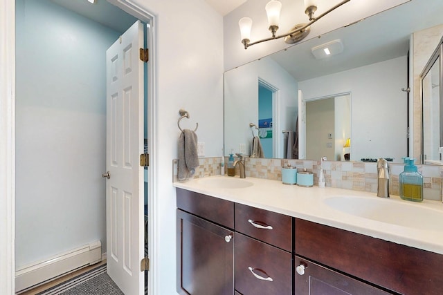 full bathroom with double vanity, a sink, a baseboard heating unit, and decorative backsplash