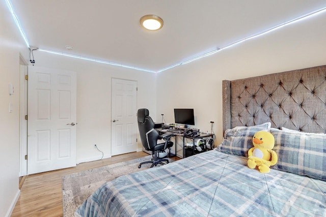 bedroom featuring baseboards and wood finished floors