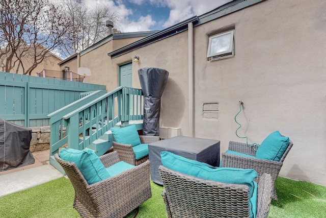view of patio with outdoor lounge area, fence, and a grill