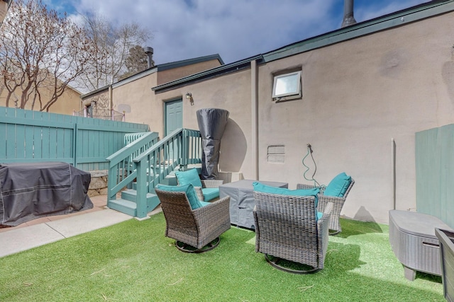 back of property with stucco siding, fence, and a lawn