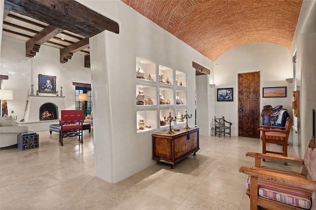 corridor featuring high vaulted ceiling and light tile patterned floors