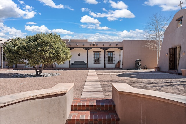 pueblo-style house with stucco siding
