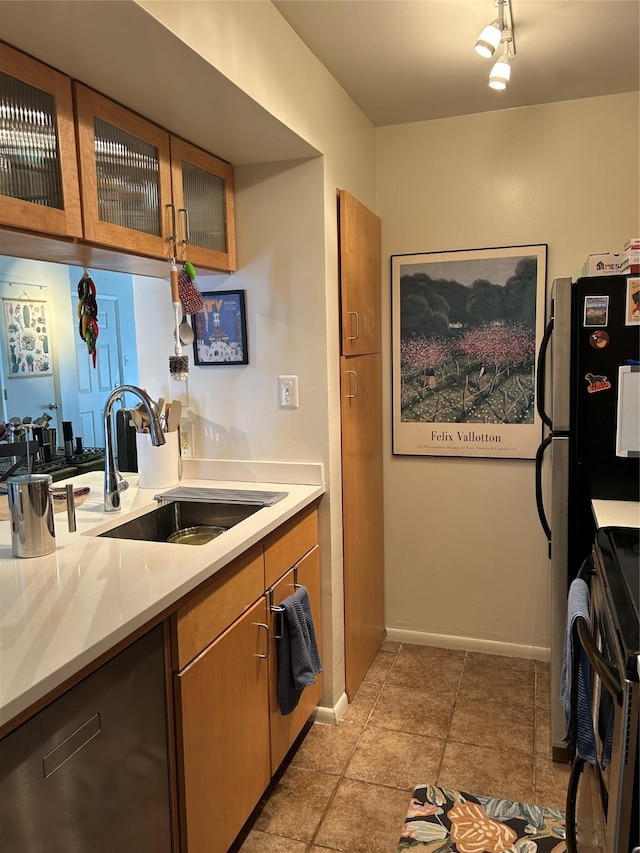 941 Calle Mejia Unit 319, Santa Fe, NM 87501 - kitchen featuring stainless steel range oven, light countertops, a sink, and glass insert cabinets