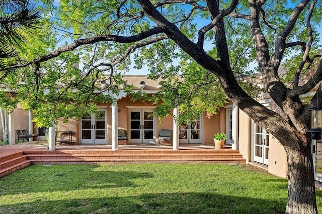 24 Paintbrush Cir, Santa Fe, NM 87506 - rear view of property featuring french doors, stucco siding, and a yard