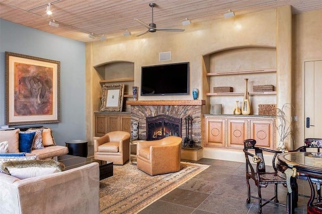 24 Paintbrush Cir, Santa Fe, NM 87506 - living room featuring rail lighting, a ceiling fan, built in features, and a stone fireplace