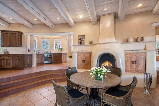 24 Paintbrush Cir, Santa Fe, NM 87506 - tiled dining space featuring wine cooler, recessed lighting, a large fireplace, and a wood ceiling with exposed beams