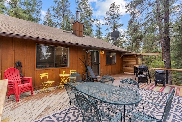 wooden terrace featuring a grill and outdoor dining area