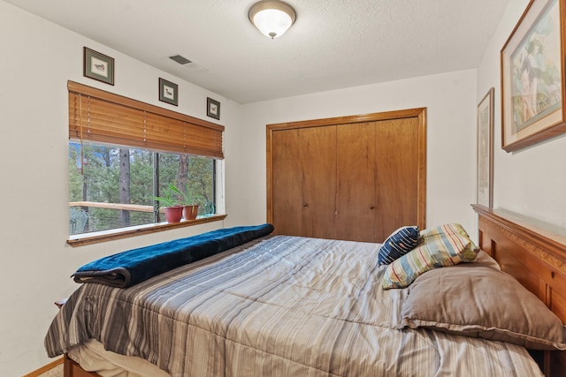 bedroom featuring visible vents, a closet, and a textured ceiling