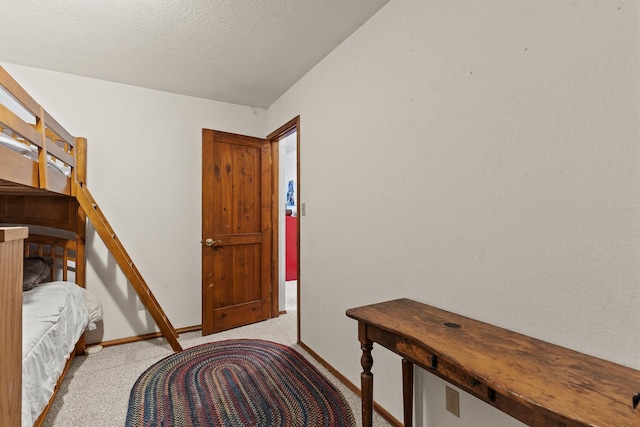 bedroom with a textured ceiling, baseboards, and carpet floors