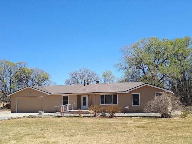 single story home with concrete driveway, a front yard, metal roof, and an attached garage