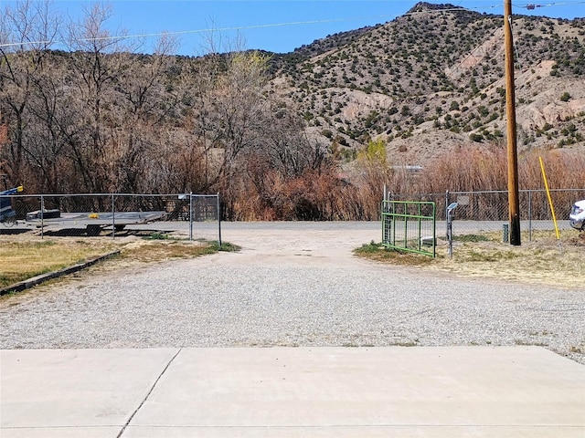 view of street featuring a mountain view and a gate