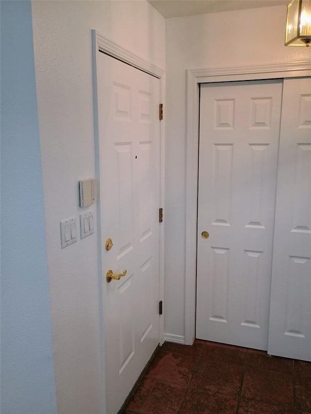 doorway featuring dark tile patterned flooring