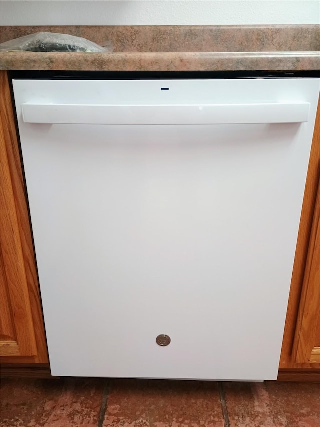 interior details featuring brown cabinets and white dishwasher