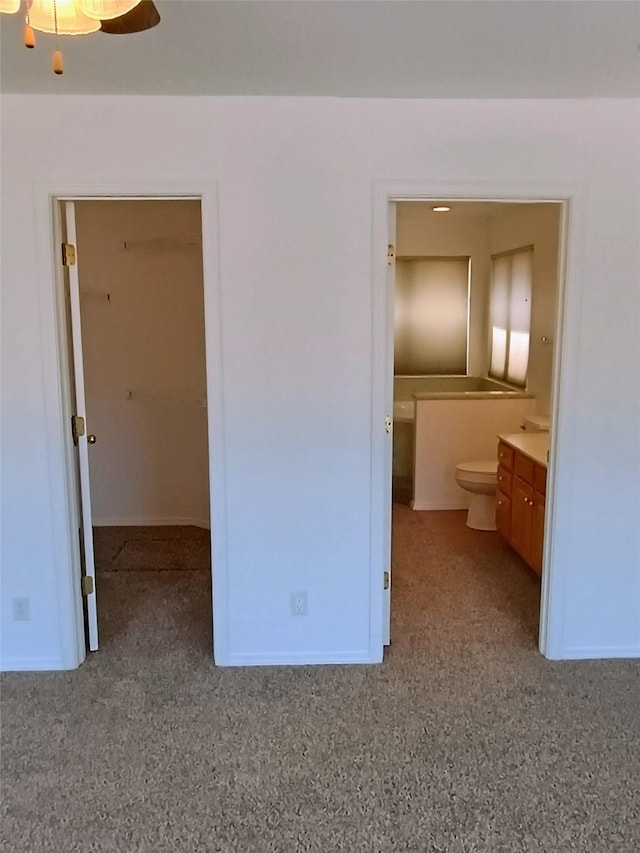 unfurnished bedroom with ensuite bath and baseboards