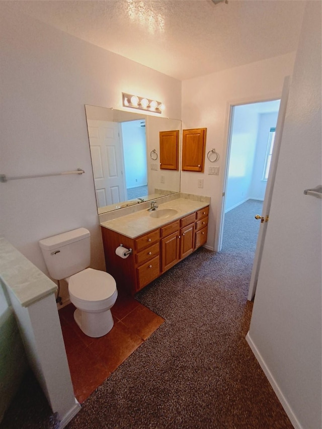 bathroom featuring toilet, vanity, and baseboards