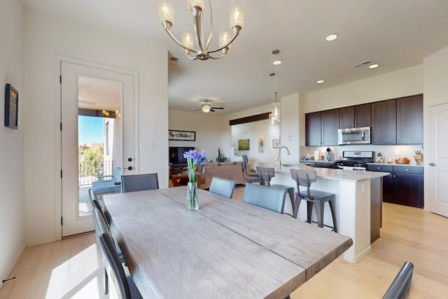 dining area with recessed lighting, light wood-style flooring, ceiling fan with notable chandelier, and visible vents