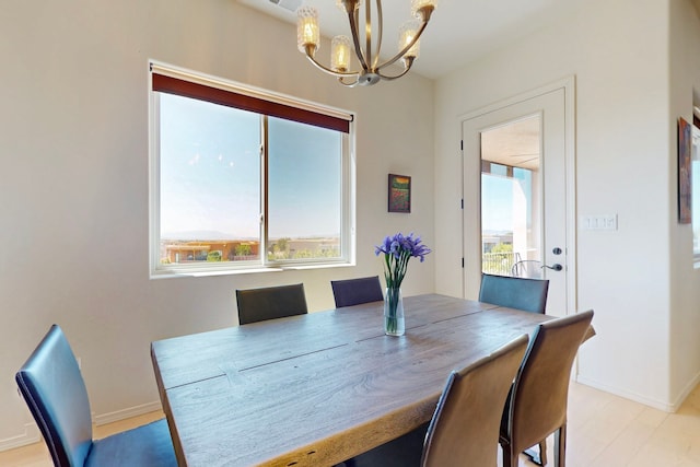 dining area with a chandelier, baseboards, and a healthy amount of sunlight