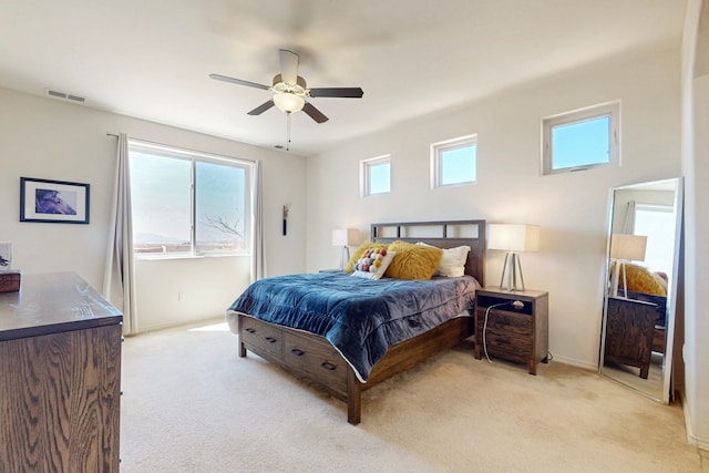 bedroom featuring light carpet, visible vents, baseboards, and a ceiling fan