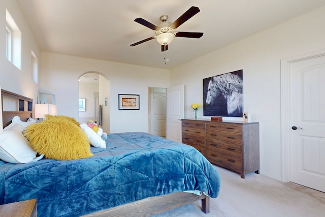 carpeted bedroom with arched walkways and ceiling fan