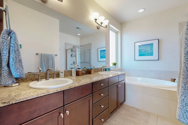 bathroom with a stall shower, a garden tub, double vanity, and a sink