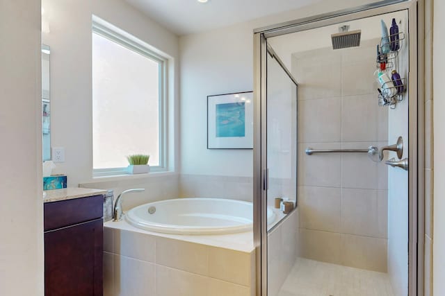 full bath with vanity, a garden tub, and a stall shower