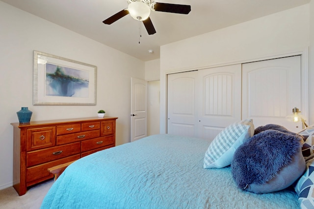 bedroom with a closet, light colored carpet, and a ceiling fan