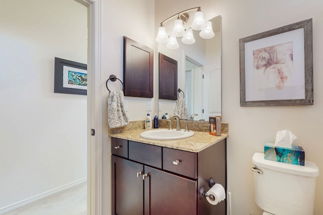 bathroom featuring vanity, baseboards, an inviting chandelier, and toilet