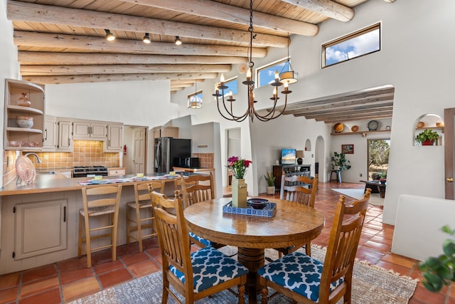 dining area featuring beamed ceiling, arched walkways, a high ceiling, and wood ceiling