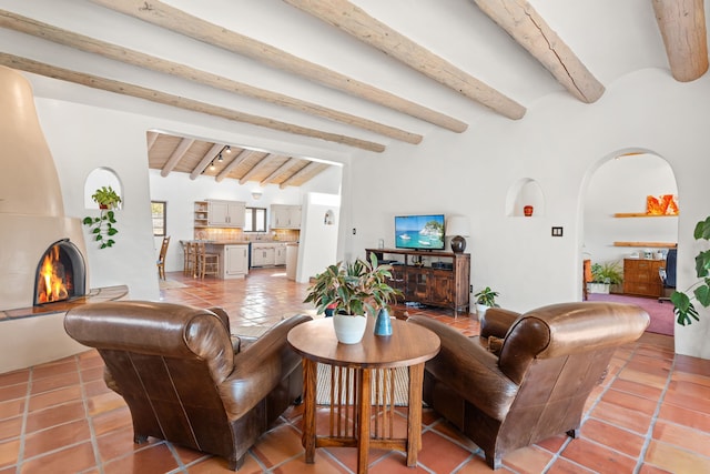 living room featuring beamed ceiling, arched walkways, and light tile patterned flooring