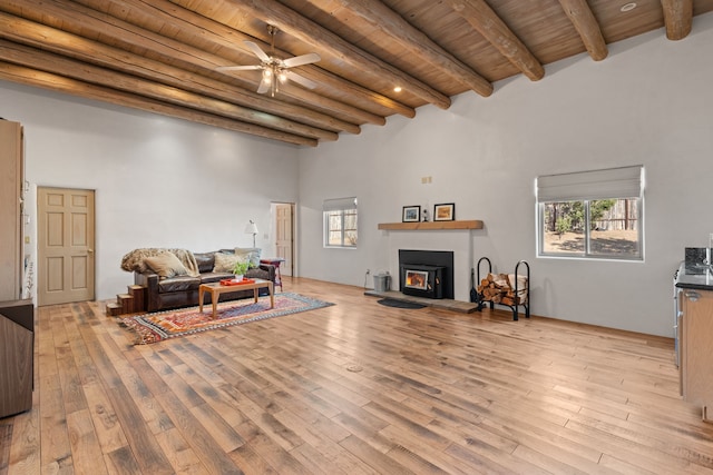 living room featuring wooden ceiling, light wood finished floors, a high ceiling, and beam ceiling