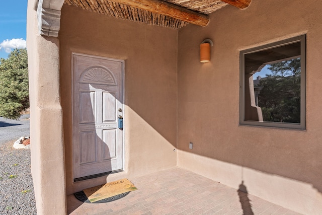 doorway to property featuring stucco siding