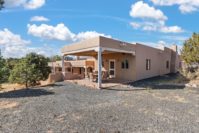 back of property with a patio, stucco siding, and fence